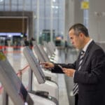 Business man at the airport checking in at ticket Kiosk.